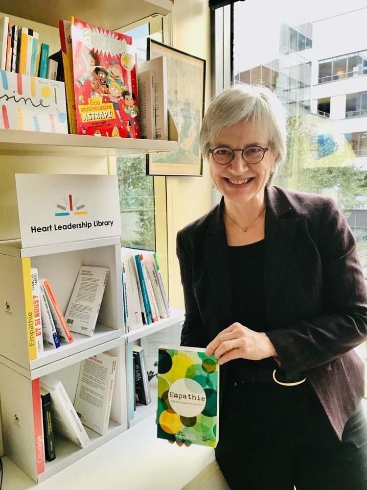 Une lectrice présente un livre devant la Heart Leadership Library