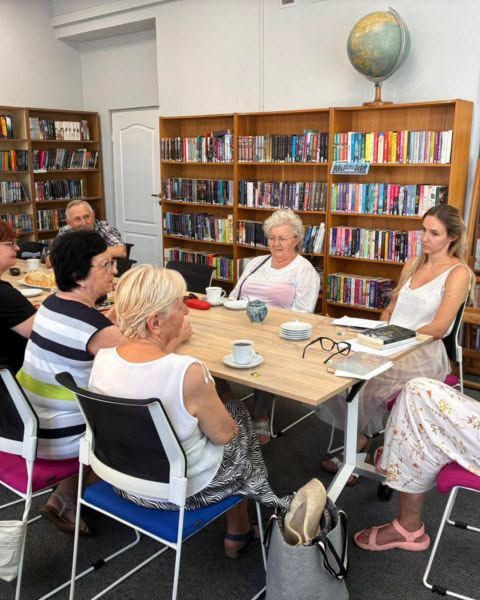 Une séance de lecture partagée autour d’une table, en bibliothèque